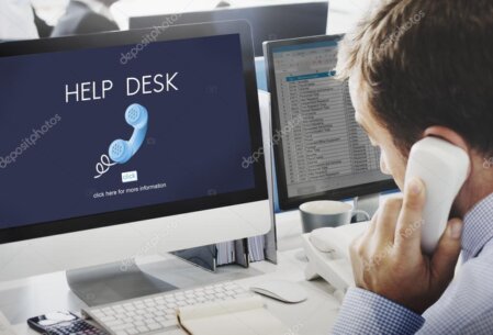 Älterer Mensch sitzt entspannt am Computer und bekommt Hilfe erklärt