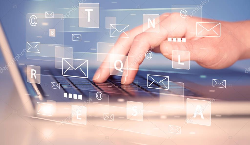 Person schreibt eine E-Mail an einem Laptop.